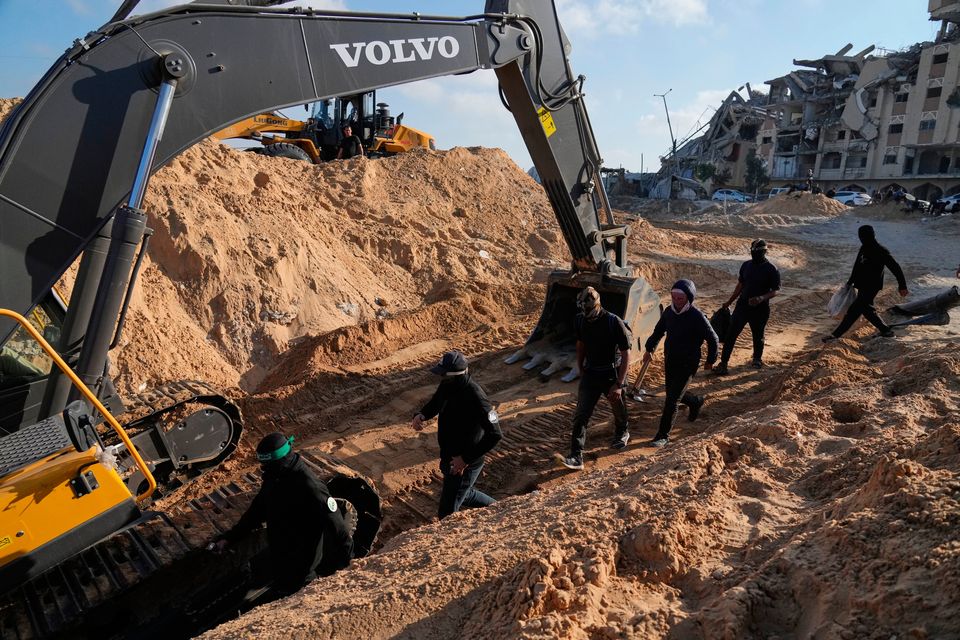 Members of the al-Qassam Brigades, the military wing of Hamas, and Egyptian workers search for the bodies of hostages in a tunnel discovered during searches in Hamad City, Khan Younis, in the southern Gaza Strip, on Tuesday, Oct. 28, 2025. (AP Photo/Jehad 